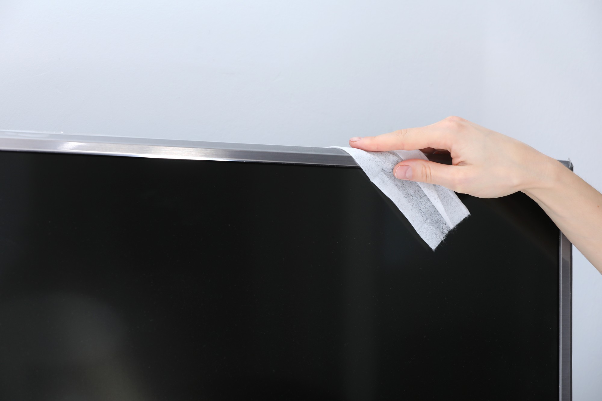 Person macht typische Fehler beim Reinigen eines Flachbildfernsehers